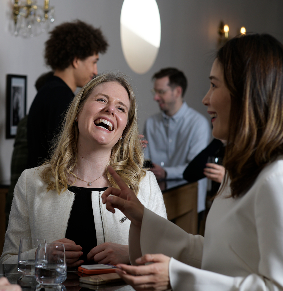 Two women smiling whilst engaged in a conversation