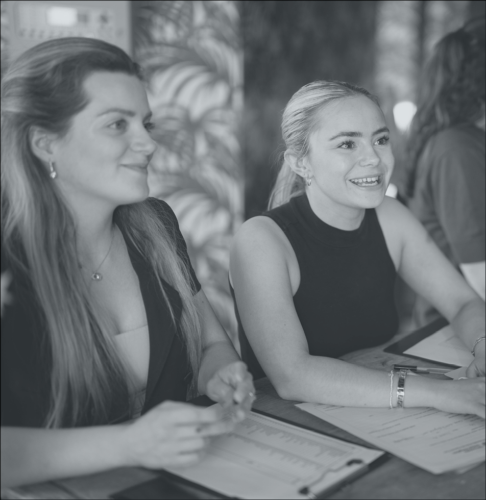 Two women smiling whilst listening