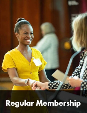 Woman in yellow dress smiling at woman